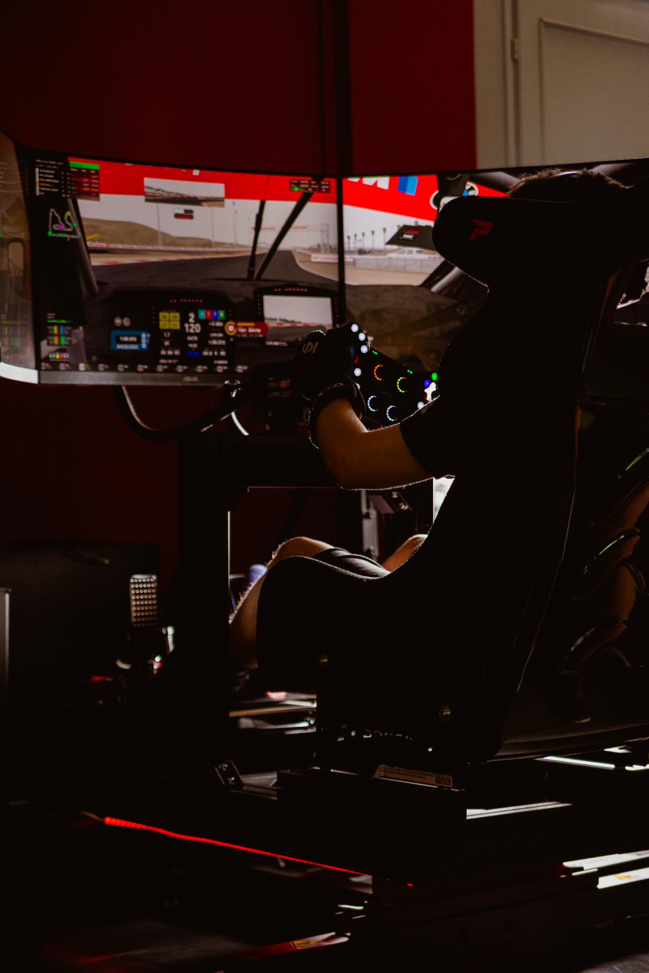 Pilota al cockpit del simulatore DSC Sassuolo con guanti e volante in pista